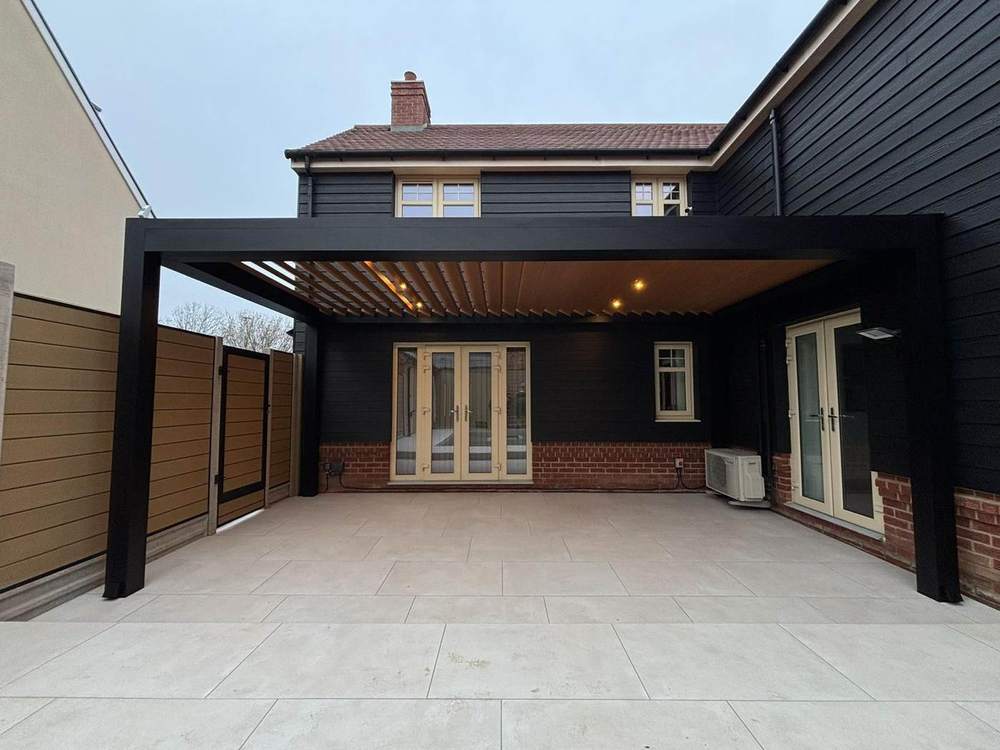 Anthracite louvered aluminium pergola against dark cladding on a contemporary home