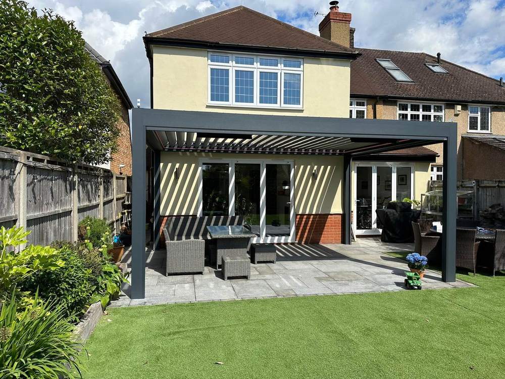 Louvered aluminium pergola over a family garden patio in daylight