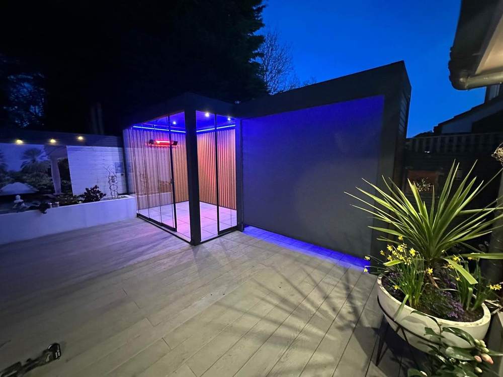 Harmony View aluminium pergola with glass side screens and integrated LED lighting at night