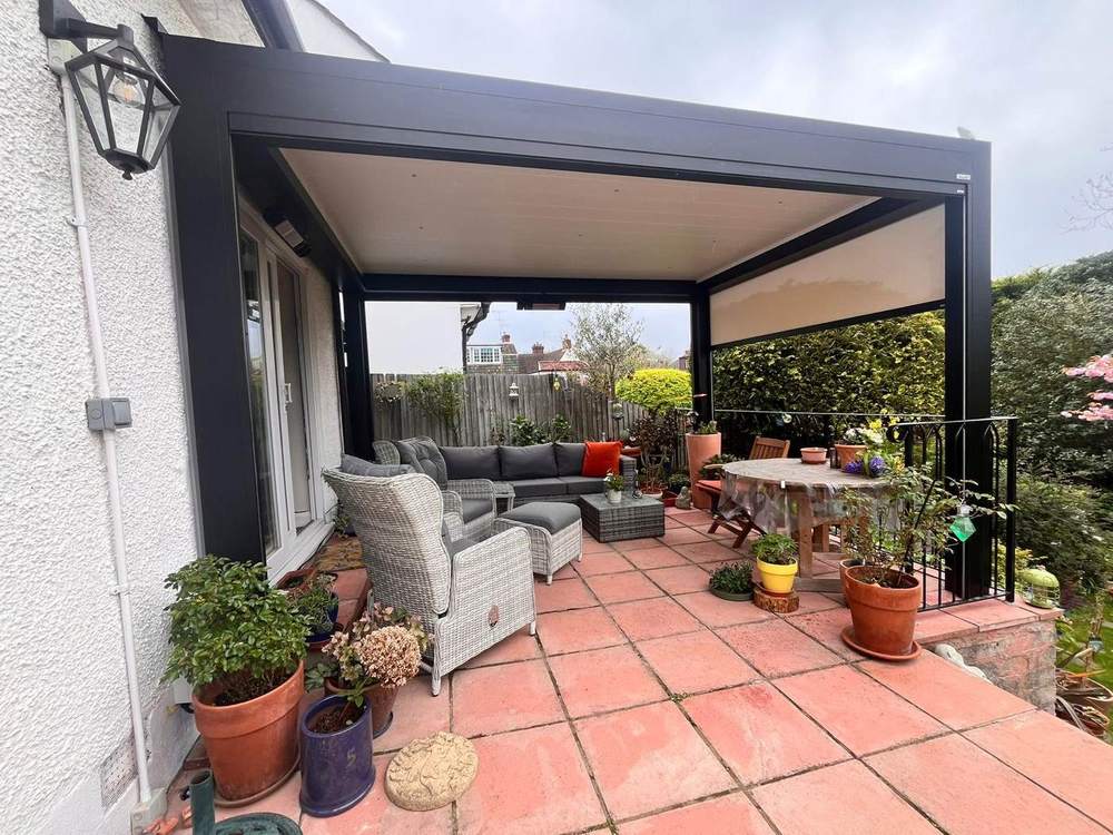 Retractable fabric roof pergola sheltering a patio seating area