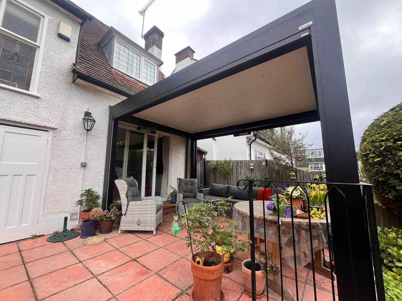 Fabric roof lean-to pergola over a terrace with potted planting