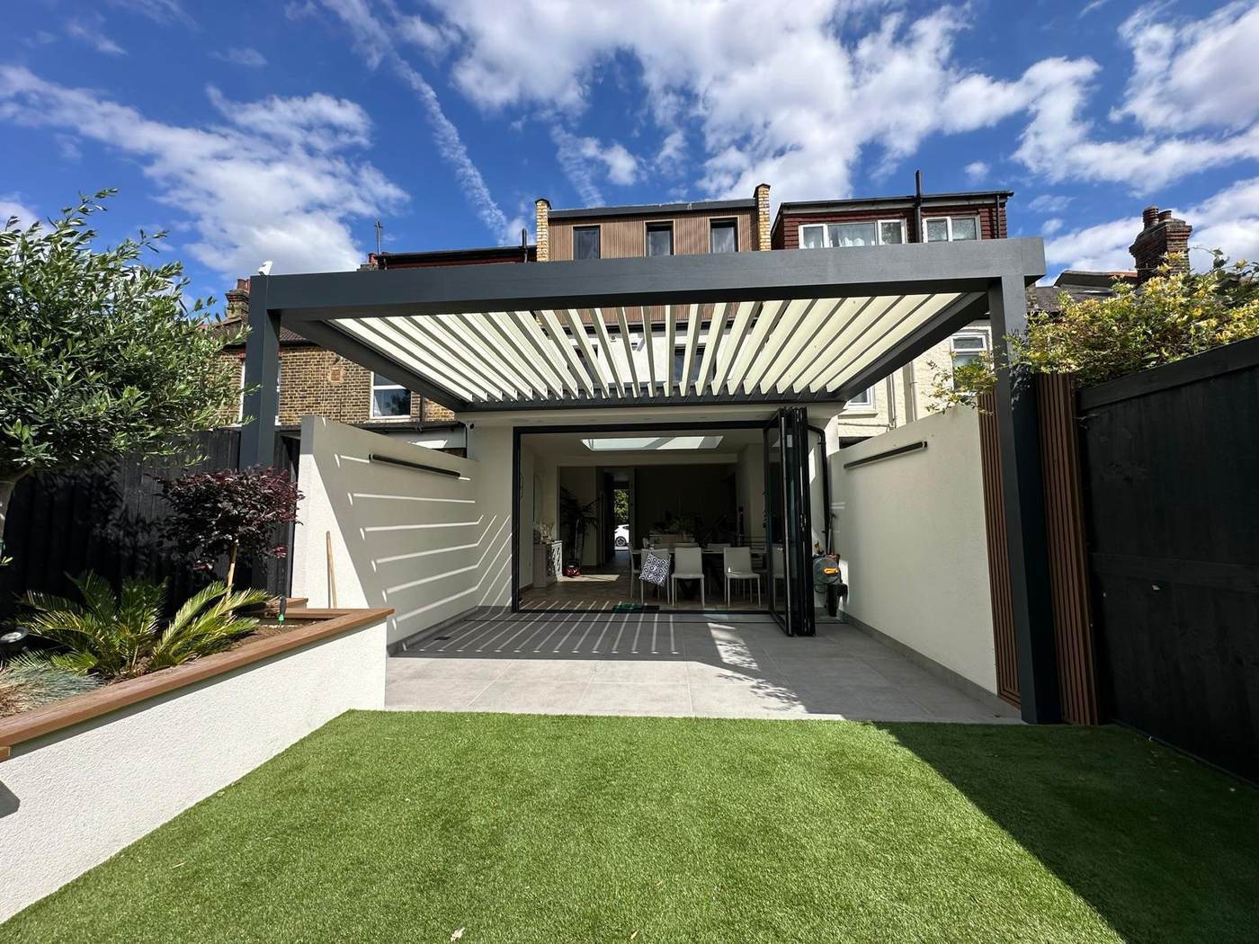 Wall mounted lean-to aluminium pergola attached to a house extension